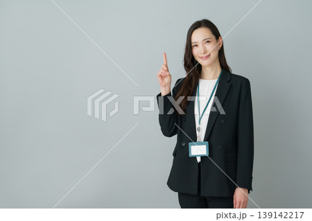 グレーバックの1番のポーズをする若いスーツの日本人女性 グレーバックの1番のポーズをする若いスーツの日本人女性 139142217