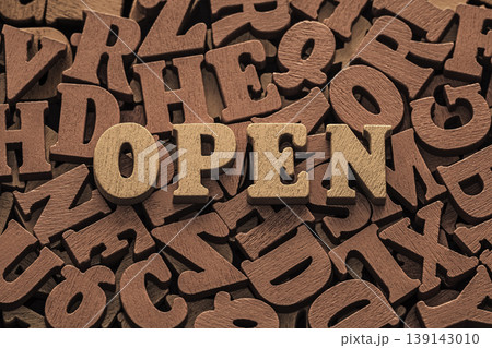 Inscription open on pile of old brown wooden letters.  139143010