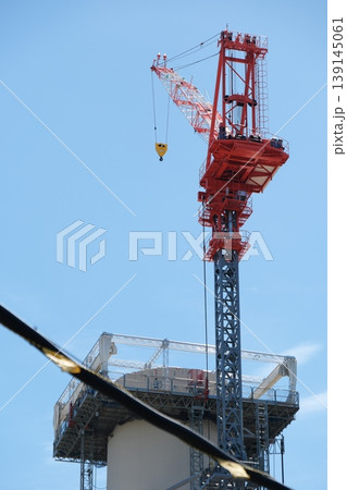 建設現場の力強さを象徴する大型クレーンと青空のクローズアップ 139145061
