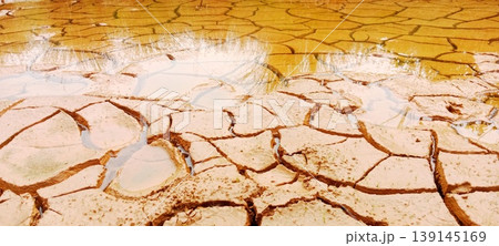 Dry mud background with puddles of water 139145169