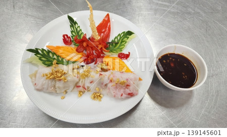 Authentic Thai Steamed Rice Noodle Rolls Garnished with Intricate Vegetable Carving Art Authentic Thai Steamed Rice Noodle Rolls Garnished with Intricate Vegetable Carving Art 139145601