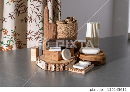 Natural Soap Bars Collection on Wooden Podiums with Rustic Bath Accessories. Assortment of Soaps and Loofah 139145611