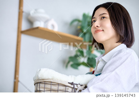 洗濯物を抱えて未来を見つめる若い女性 139145743