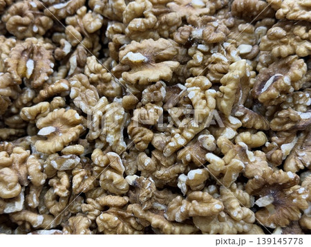 Walnut halves create a textured background featuring natural patterns and brown hues Walnut halves create a textured background featuring natural patterns and brown hues 139145778