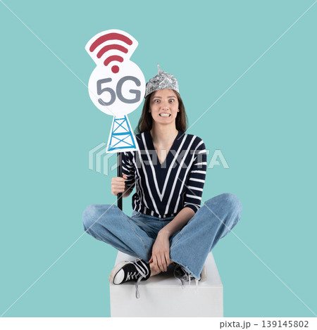 Woman fears 5g radiation wearing tinfoil hat Woman fears 5g radiation wearing tinfoil hat 139145802