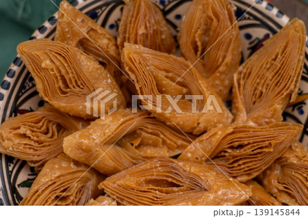 Crimean Tatar Baklava, a traditional pastry in bowl. Sweet diamond shapes food closeup Crimean Tatar Baklava, a traditional pastry in bowl. Sweet diamond shapes food closeup 139145844