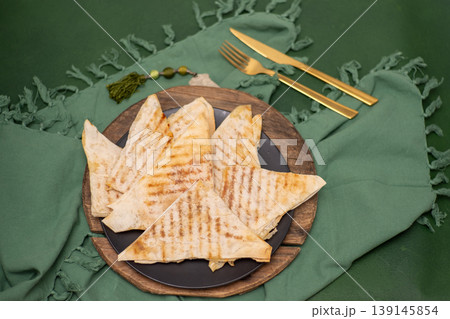 Saudi Arabia food Mutabbaq thin triangular envelopes of dough with filling fried in a pan. Flatbread is a traditional Arabic food. 139145854