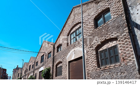Old Industrial Brick Building Facade Under Blue Sky 139146417