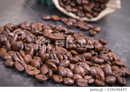 Heap of dark roasted coffee grains in jute bag 139146447