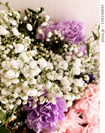 Vibrant bouquet with mix of beautifully arranged flowers including bright purple and soft pink blooms. Delicate greenery adds elegant touch, while sprigs of baby breath enhance bouquet charm 139146695