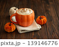 Cozy pumpkin latte in a pumpkin shaped latte mug with whipped cream and spices 139146776