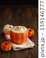 Cozy pumpkin latte in a pumpkin shaped latte mug with whipped cream and spices 139146777