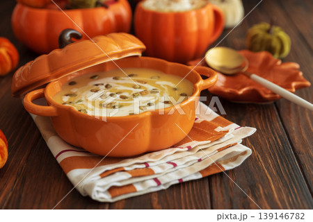 Autumnal lunch with pumpkin soup in a pumpkin-shaped bowl, pumpkin latte, croutons and festive decor 139146782