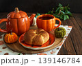 Autumnal tea set with pumpkin shaped teapot and mug, and a baked buns 139146784