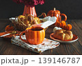 Autumnal tea set with baked buns into basket, pumpkin shaped teapot and mug 139146787