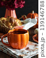 Autumnal tea set with baked buns into basket, pumpkin shaped teapot and mug 139146788