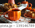 Autumnal tea set with baked buns into basket, pumpkin shaped teapot and mug 139146789