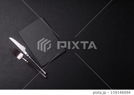 An empty slate cutting board with cutlery on a kitchen counter. Slate cutting board An empty slate cutting board with cutlery on a kitchen counter. Slate cutting board 139146894