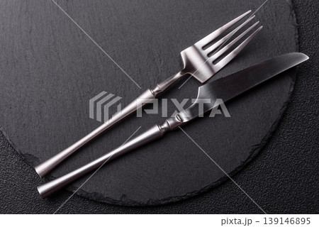 An empty slate cutting board with cutlery on a kitchen counter. Slate cutting board An empty slate cutting board with cutlery on a kitchen counter. Slate cutting board 139146895