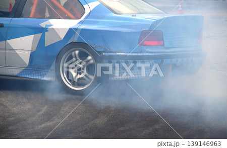 Drifting car in smoke from burning tires on the track in motion 139146963