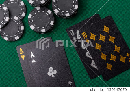 Playing cards and chips on a green cloth, a gambling game of blackjack or baccarat. Cards and chips Playing cards and chips on a green cloth, a gambling game of blackjack or baccarat. Cards and chips 139147070