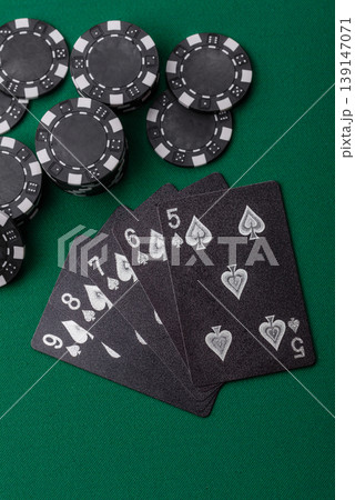 Playing cards and chips on a green cloth, a gambling game of poker. Cards and chips 139147071