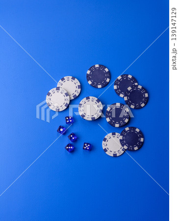 Casino dice and chips on a colored background, poker, gambling with bets. Dice and chips Casino dice and chips on a colored background, poker, gambling with bets. Dice and chips 139147129