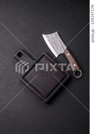 An empty wooden cutting board with cutlery on a kitchen counter. A wooden cutting board An empty wooden cutting board with cutlery on a kitchen counter. A wooden cutting board 139147176