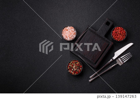 An empty wooden cutting board with cutlery on a kitchen counter. A wooden cutting board 139147263