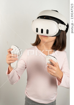 Child plays with virtual reality headset and controllers at home Child plays with virtual reality headset and controllers at home 139147323