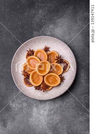 Round mini tartlets with citrus or peach jam and crumbly pastry. Mini citrus tarts 139147411