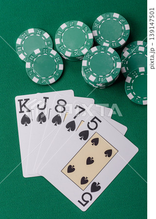 Playing cards and chips on a green cloth, a gambling game of poker. Cards and chips Playing cards and chips on a green cloth, a gambling game of poker. Cards and chips 139147501