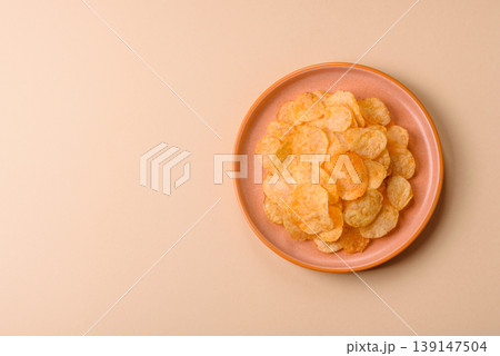 Crispy potato chips, golden slices seasoned with salt and spices. Potato chips 139147504