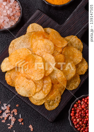 Crispy potato chips, golden slices seasoned with salt and spices. Potato chips Crispy potato chips, golden slices seasoned with salt and spices. Potato chips 139147505
