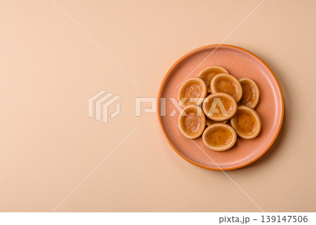Round mini tartlets with citrus or peach jam and crumbly pastry. Mini citrus tarts 139147506