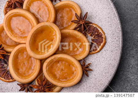 Round mini tartlets with citrus or peach jam and crumbly pastry. Mini citrus tarts 139147507