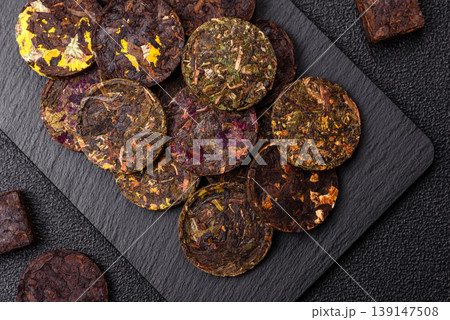 Organic Chinese green pu-erh tea with various herbs in round bricks. Chinese pu-erh tea 139147508