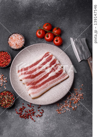 Raw fresh bacon slices with layers of meat or prosciutto prepared for frying. Raw bacon Raw fresh bacon slices with layers of meat or prosciutto prepared for frying. Raw bacon 139147546