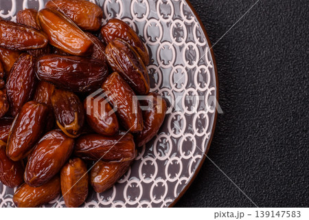 Dried dates on a ceramic plate for Ramadan or Iftar. Dates fruit as a background Dried dates on a ceramic plate for Ramadan or Iftar. Dates fruit as a background 139147583