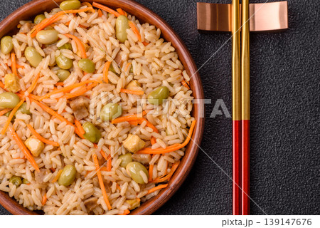 Asian food with rice, edamame, carrots, tofu, and spices. Rice with edamame and carrots 139147676