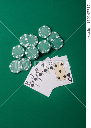 Playing cards and chips on a green cloth, a gambling game of poker. Cards and chips Playing cards and chips on a green cloth, a gambling game of poker. Cards and chips 139147717