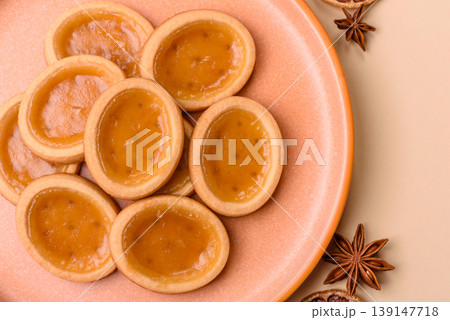 Round mini tartlets with citrus or peach jam and crumbly pastry. Mini citrus tarts 139147718