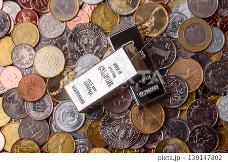 A silver bar, white metal against a backdrop of money, as a concept for the sales. A silver bar 139147802