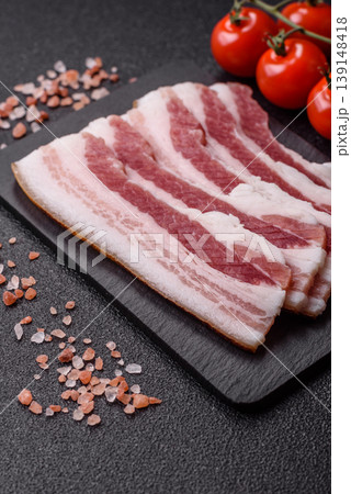 Raw fresh bacon slices with layers of meat or prosciutto prepared for frying. Raw bacon Raw fresh bacon slices with layers of meat or prosciutto prepared for frying. Raw bacon 139148418