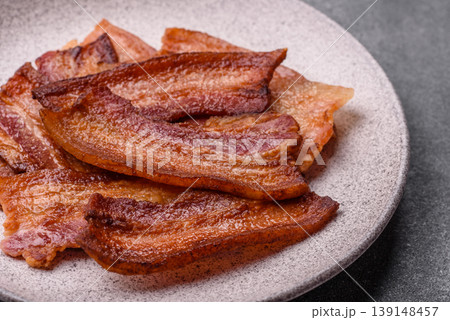 Fried fresh bacon slices with layers of meat or prosciutto prepared for breakfast. Fried bacon Fried fresh bacon slices with layers of meat or prosciutto prepared for breakfast. Fried bacon 139148457