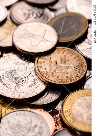 A background of silver, gold, and copper coins of various denominations. Metal coins 139148619