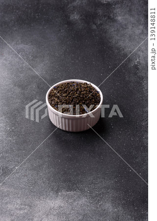 Granules of dried organic Chinese green tea with herbal additives. Dry green tea Granules of dried organic Chinese green tea with herbal additives. Dry green tea 139148811