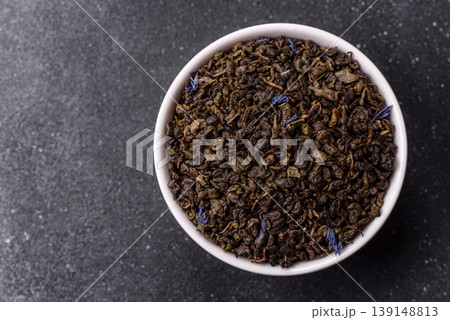 Granules of dried organic Chinese green tea with herbal additives. Dry green tea Granules of dried organic Chinese green tea with herbal additives. Dry green tea 139148813