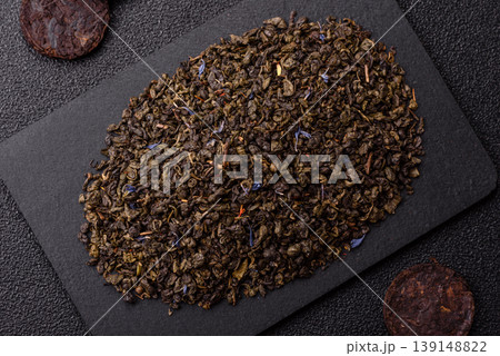 Granules of dried organic Chinese green tea with herbal additives. Dry green tea 139148822