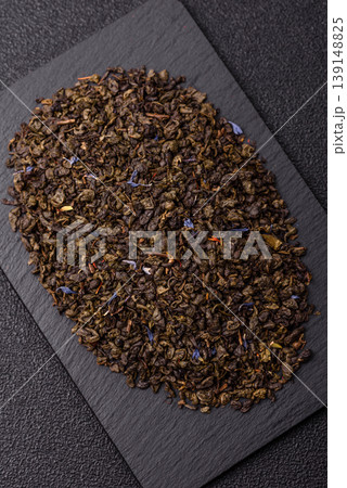 Granules of dried organic Chinese green tea with herbal additives. Dry green tea Granules of dried organic Chinese green tea with herbal additives. Dry green tea 139148825